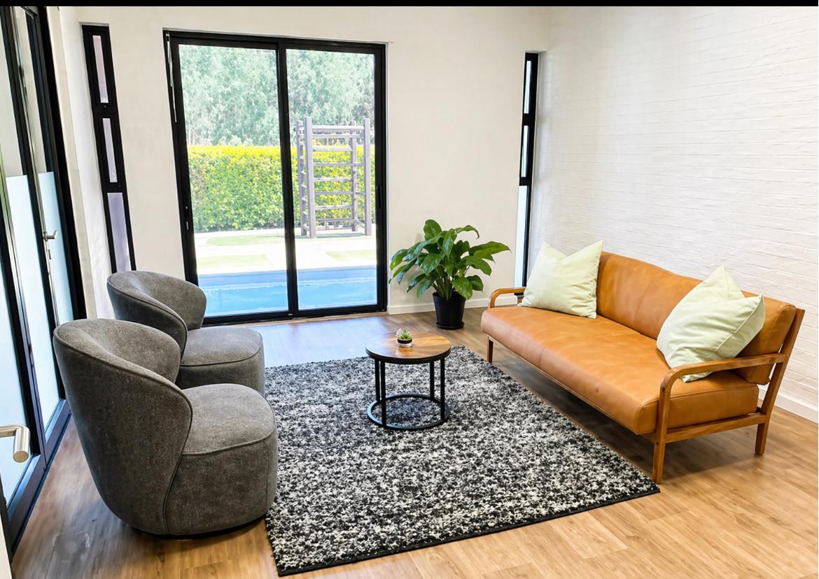 The H.U.G.S Child Therapy private practice room in Protea Valley, Cape Town — a calm, welcoming space with warm natural light, cosy seating and garden views